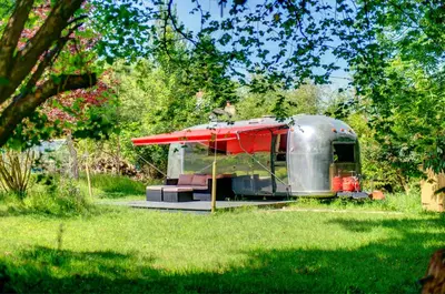 a silver trailer with a red roof in a field at Vintage glamping Airstream with Farm Animals in Penryn