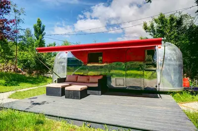 a trailer with a red roof with a couch in it at Vintage glamping Airstream with Farm Animals in Penryn