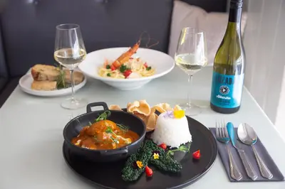 a table with a plate of food and a bottle of wine at Mannings Hotel in Truro