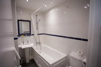 a bathroom with a tub and a sink and a toilet at Mannings Hotel in Truro