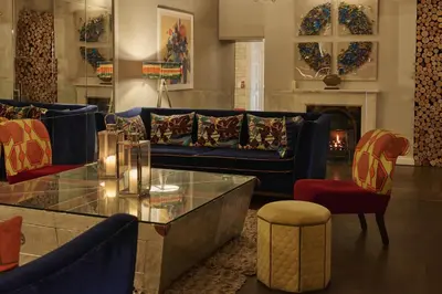 a living room with a couch and a table and chairs at Harbour Hotel & Spa St Ives in St Ives