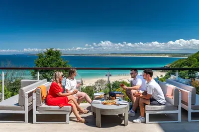 a group of people sitting around a table on a patio at Harbour Hotel & Spa St Ives in St Ives