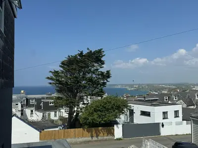 a view of a city with a tree and the ocean at OYO Shore Surf Lodge in Newquay