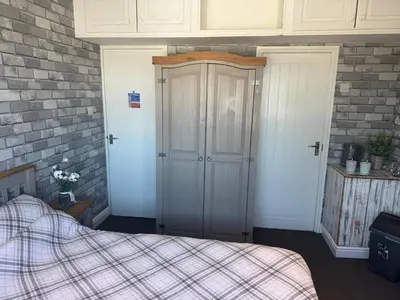 a bedroom with a bed and a brick wall at OYO Shore Surf Lodge in Newquay