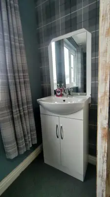 a bathroom with a white sink and a mirror at OYO Shore Surf Lodge in Newquay