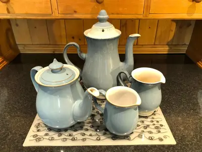 a tea pot and three cups on a table at Central Boscastle studio flat in Boscastle