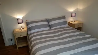 a bedroom with two lamps on two night stands at Sunways in Padstow