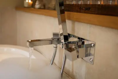 a bathroom sink with water pouring from a faucet at The Home Barn at Cornish Barn Holidays in Perranwell