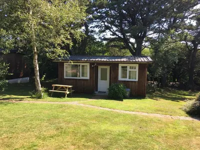 a small shed with a picnic table in a yard at Mount Hawke Holiday Bungalows in Porthtowan