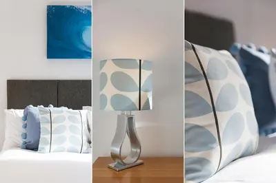 a bedroom with a bed with a lamp and pillows at Tara in St Ives
