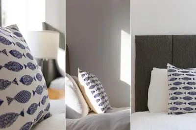 a bedroom with blue and white pillows and a bed at Tara in St Ives