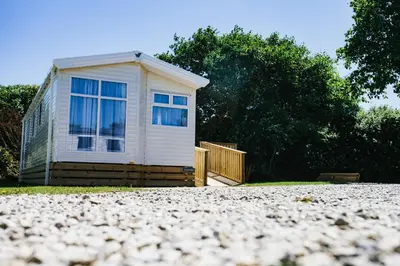 a small white house with a window in a driveway at Little treamble holidays in Cubert