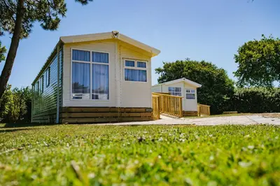 a small house with a porch on a lawn at Little treamble holidays in Cubert
