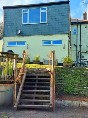 a house with a staircase in front of a house at Sportsmans Valley Hotel in Liskeard