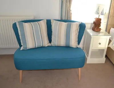 a blue chair with two pillows on top of it at Tregony Guest House in St Ives