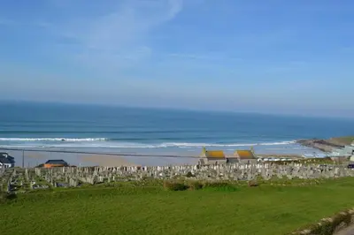 a beach with a bunch of chairs and the ocean at Tregony Guest House in St Ives