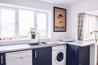 a kitchen with a sink and a washing machine at Harvest Moon in Newquay