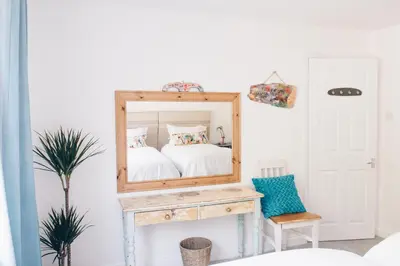 a mirror on a table in a room with a bed at Harvest Moon in Newquay