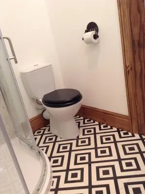 a bathroom with a toilet with a black seat at Treganoon House, Lanlivery in Bodmin