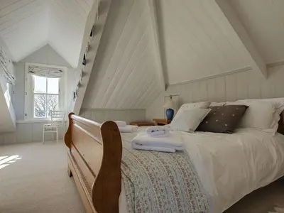 a bedroom with a large bed with a wooden frame at 1 Florence Place in Falmouth