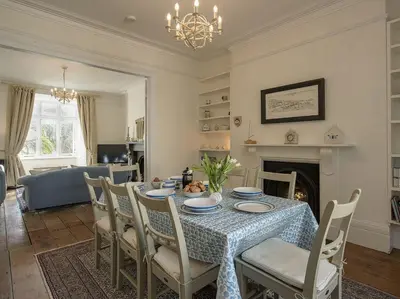 a dining room with a table with chairs and a fireplace at 1 Florence Place in Falmouth