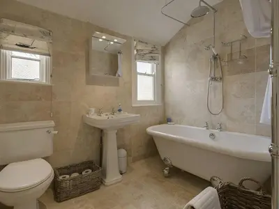a bathroom with a tub and a toilet and a sink at 1 Florence Place in Falmouth
