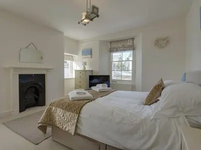 a bedroom with a large bed and a fireplace at 1 Florence Place in Falmouth