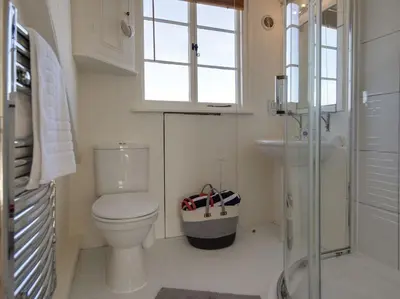 a bathroom with a toilet and a sink and a window at 1 Florence Place in Falmouth