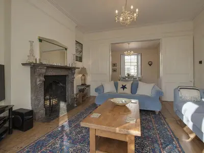 a living room with a blue couch and a fireplace at 1 Florence Place in Falmouth
