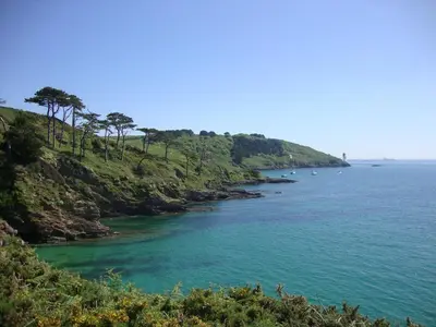 a view of a body of water with trees on a hill at Stones Throw in Saint Mawes