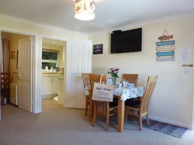 a dining room with a table with a sign on it at Stones Throw in Saint Mawes