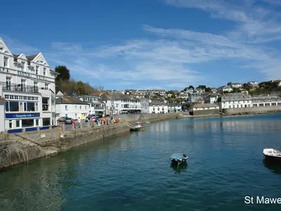 a small boat in a river in a town at Stones Throw in Saint Mawes