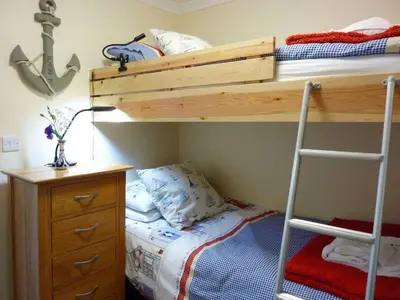 a bedroom with a bunk bed and a desk at Stones Throw in Saint Mawes