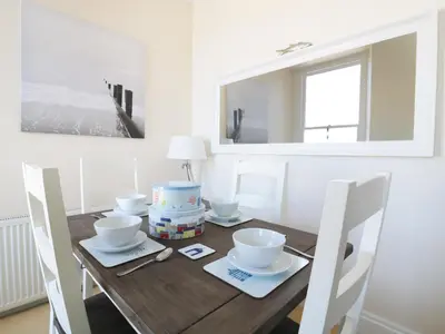 a dining room with a wooden table and chairs at Seashore House in Newquay