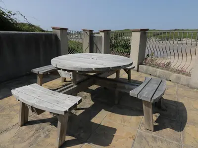 a picnic table and two benches on a patio at Seashore House in Newquay
