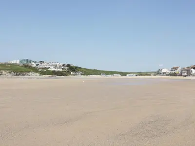 an empty beach with houses in the background at Seashore House in Newquay