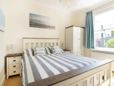 a bedroom with a large bed and a window at Seashore House in Newquay