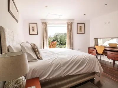 a bedroom with a bed and a desk and a window at Chy Lagen Hos in Newquay