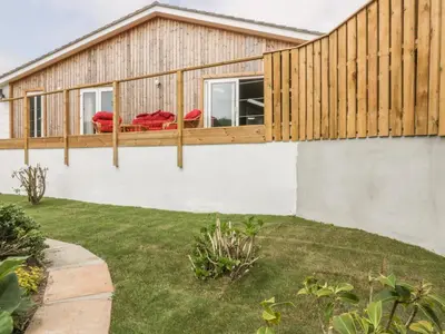 a house with a deck and a fence at Chy Lagen Hos in Newquay