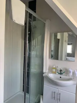 a bathroom with a glass shower and a sink at The Red House Guest House in Falmouth