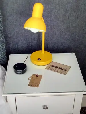 a yellow lamp on top of a white night stand at The Red House Guest House in Falmouth