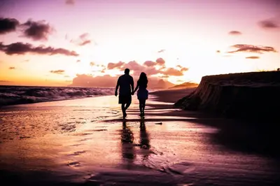 a couple walking on the beach at sunset at Fairways Guest House in Newquay