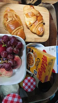 a table with a plate of bread and grapes and croissants at Fairways Guest House in Newquay