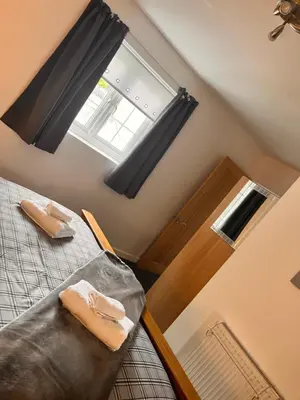 a bedroom with a bed and a window and a door at The Cottage in Redruth