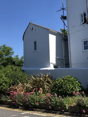 a white building with flowers in front of it at The Cottage in Redruth