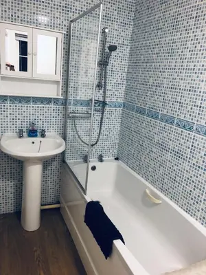 a bathroom with a tub and a sink and a shower at The Cottage in Redruth