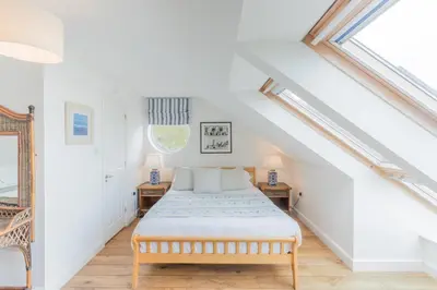 a bedroom with a bed and two night stands at Tolcarne Beach Apartments in Newquay