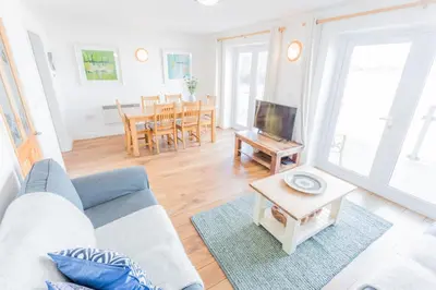 a living room with a couch and a table at Tolcarne Beach Apartments in Newquay