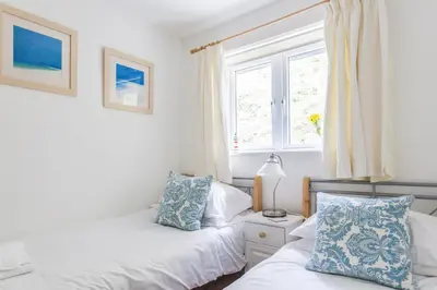 a bedroom with two beds and a window at Tolcarne Beach Apartments in Newquay