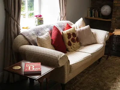 a couch with pillows on it in a living room at Pengelly Farmhouse B&B in Truro